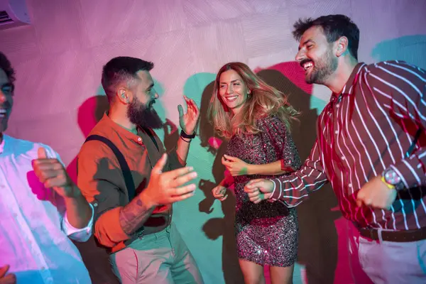 Bir grup neşeli genç arkadaş bir partide şarkı söyleyip dans ediyor.