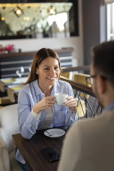 Bir çift restoranda buluşuyor, sohbet ediyor ve kahve içiyor.