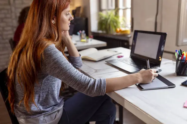 Modern bir ortak çalışma alanında yeni bir proje üzerinde çalışan kadın tasarımcı; çizim tahtası üzerinde çizim yapan web tasarımcısı. Eline odaklan.