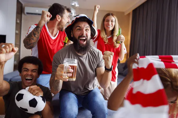 Neşeli arkadaşlar futbol fanatikleri eğleniyorlar, bira içiyorlar ve televizyonda dünya şampiyonluğu maçı izliyorlar.