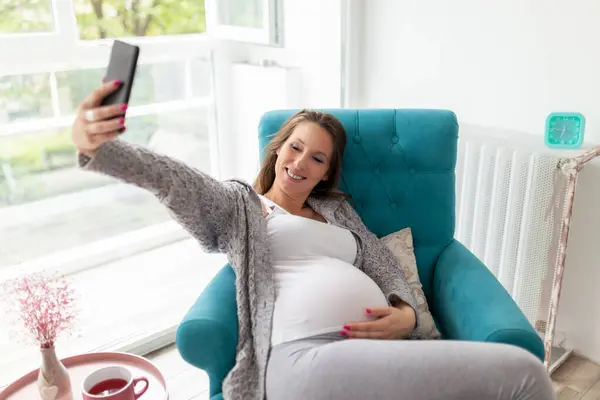 Pregnant Woman Relaxing Home Sitting Armchair Drinking Tea Taking Selfies — Stock Photo, Image