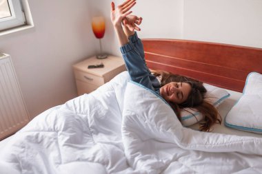 Sabahları pijama giyen, esneyen ve esneyen güzel bir kadının yüksek açılı görüntüsü.