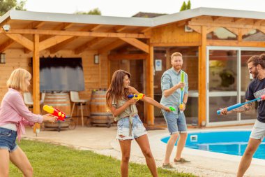 Bir grup genç arkadaş yaz günlerini dışarıda, su tabancalarıyla oynayarak, birbirlerine su sıçratarak, yüzme havuzunda birbirlerini kovalayarak geçiriyorlar.