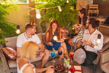 Doğum günü partisinde eğlenen arkadaşlar, pastayı kesip paylaşan doğum günü kızı.