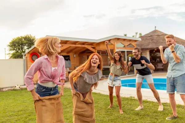 Group Cheerful Young Friends Having Fun While Racing Jumping Sacks — Stock Photo, Image
