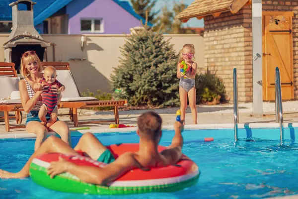 Fröhliche Eltern Die Mit Ihren Kindern Mit Spritzpistolen Pool Spielen — Stockfoto