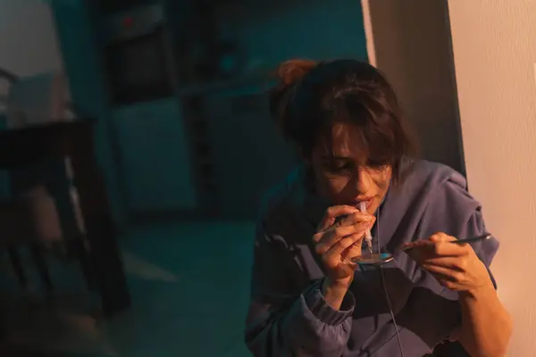 女性吸毒者在黑暗中坐在厨房地板上 用注射器和勺子准备下一次静脉注射海洛因 吸毒成瘾的概念 — 图库照片