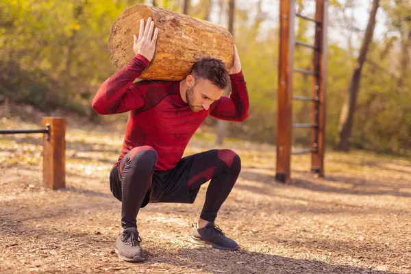 Adam Çömelirken Ağaç Kütüğü Kaldırıyor Sokak Çalışma Parkında Egzersiz Yapıyor — Stok fotoğraf
