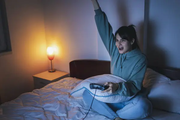 Красивая Молодая Женщина Пижаме Веселится Дома Играет Видеоигры Постели Ночью — стоковое фото