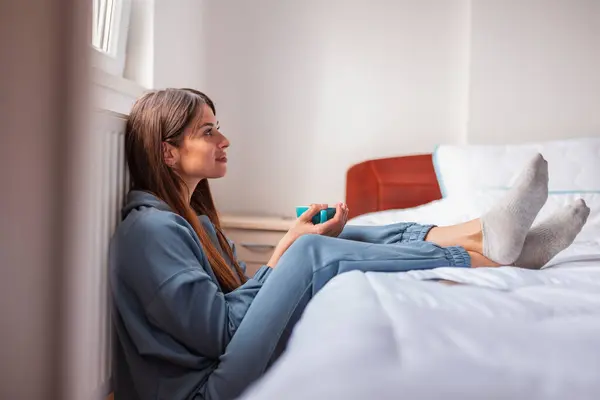 Pijama Giyen Güzel Genç Bir Kadın Yatak Odasındaki Yatağın Yanında — Stok fotoğraf