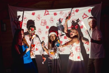 Bir grup arkadaş yeni yıl partisinde eğleniyor, parti ıslıkları çalıyor ve gece yarısı havai fişeklerle el sallıyorlar.