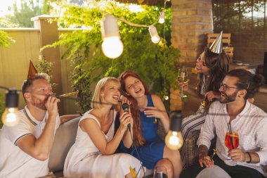 Bir grup genç arkadaş bir doğum günü partisinde karaoke söyleyip kokteyl içerek eğleniyor.