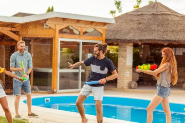 Bir grup genç arkadaş yaz günlerini dışarıda, su tabancalarıyla oynayarak, birbirlerine su sıçratarak, yüzme havuzunda birbirlerini kovalayarak geçiriyorlar.