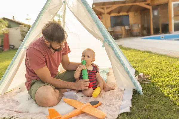 彼の赤ん坊の男の子と遊んで楽しんでいる若い父親 晴れた夏の日にプールで裏庭でキャンプ — ストック写真