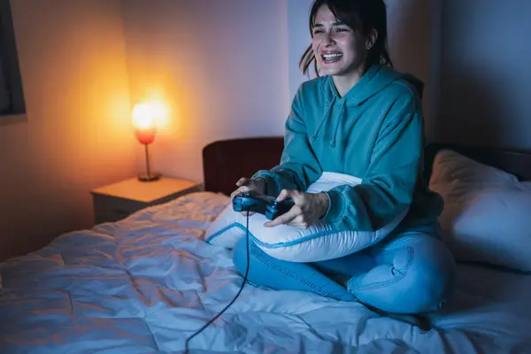 Красивая Молодая Женщина Пижаме Веселится Дома Играет Видеоигры Постели Ночью — стоковое фото