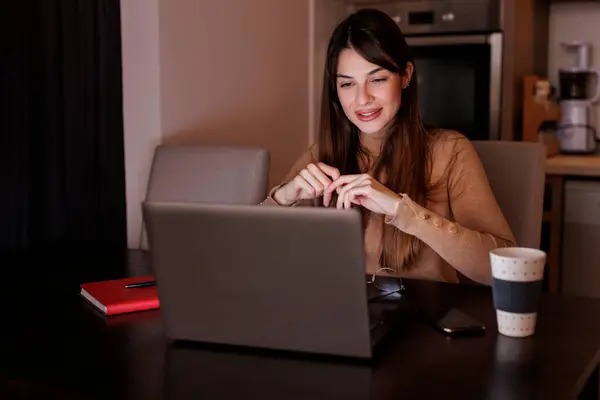 ラップトップコンピュータを使用して残業中に自宅のオフィスで彼女の机に座っている女性 オンラインクラスコースを受講する女性 — ストック写真
