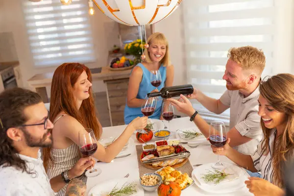 Hombre Sirviendo Vino Sus Amigos Mientras Hace Una Cena Casa —  Fotos de Stock