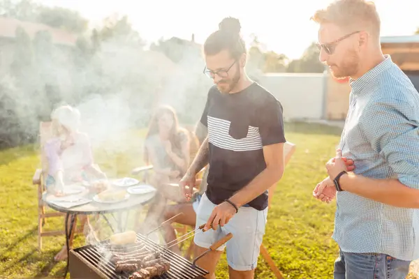 一群年轻的朋友在后院举行烧烤派对 一边烤肉一边玩乐 同时在户外度过阳光灿烂的夏天 — 图库照片