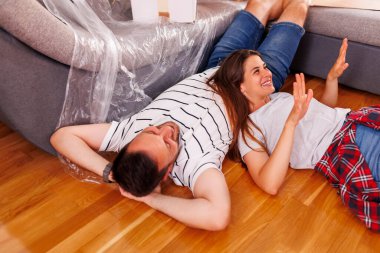 Güzel, birbirine aşık genç bir çift yeni evlerinin zemininde uzanıyor ve dinleniyor, birlikte yaşamaya devam ederken mola veriyorlar.