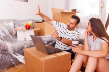 Birbirine aşık güzel genç bir çift birlikte yaşıyor, kahve içiyor ve internette dizüstü bilgisayar kullanarak sörf yapıyor.