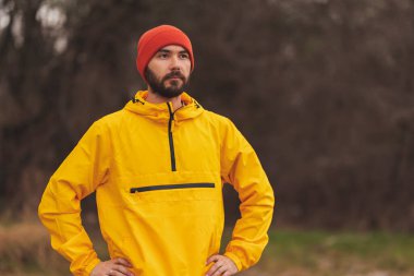 Adam bulutlu bir sonbahar gününde sabah sabah parkta koşuyor.