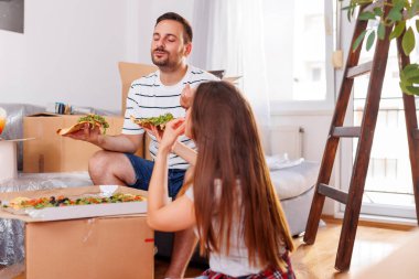 Birbirine aşık bir çift birlikte yaşıyor, karton kutuları açmaya ara veriyor, öğle yemeğinde pizza yerken eğleniyor.