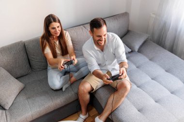 Mutlu çiftin video oyunu oynayıp, evde vakit geçirmesinin yüksek açılı görüntüsü