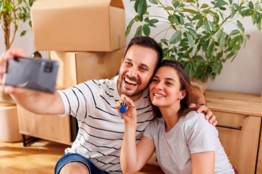 Birbirine aşık genç bir çift yeni evlerine taşınıyor. Apartman anahtarlarıyla selfie çekerken eğleniyorlar.