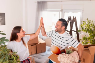 Güzel, genç bir çift yeni bir eve taşınırken eğleniyor. Karton kutular taşırken beşlik çakıyorlar.