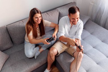 Mutlu çift evde boş zamanlarını geçirirken video oyunu oynayarak eğleniyor.