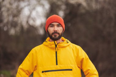 Adam bulutlu bir sonbahar gününde sabah sabah parkta koşuyor.