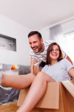 Güzel bir çift yeni evine taşınıyor, karton kutularını eşyalarıyla açarken eğleniyor, koca karısını karton bir kutuda itiyor.