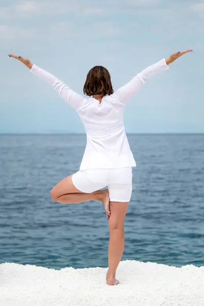 希腊塔索斯岛大理石海滩附近练习瑜伽的年轻女子 — 图库照片