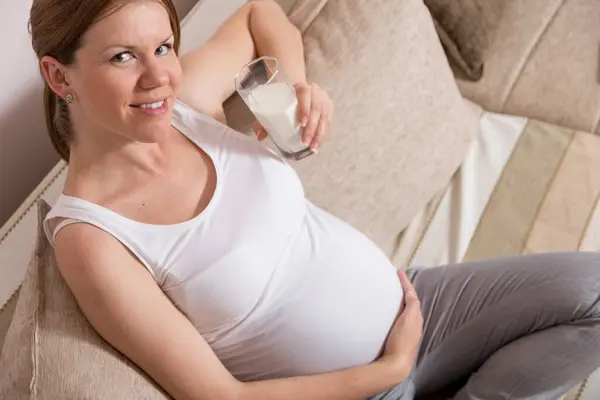 Beautiful Pregnant Woman Sitting Couch Living Room Holding Glass Milk — Stock Photo, Image