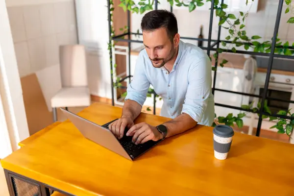 自宅のオフィスでリモートで作業しながらラップトップコンピュータを使用する人の高角度ビュー — ストック写真