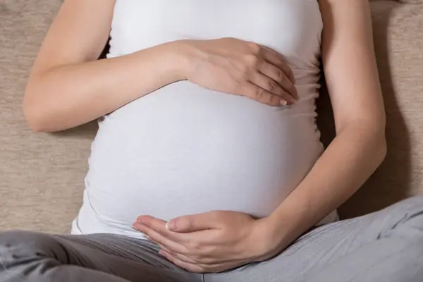 Acercamiento Del Vientre Una Mujer Embarazada Mientras Está Sentada Sofá — Foto de Stock
