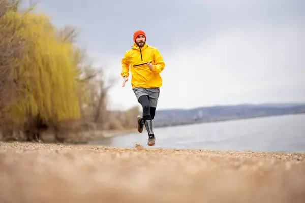 曇った秋の日に川で走る朝の運動選手 — ストック写真