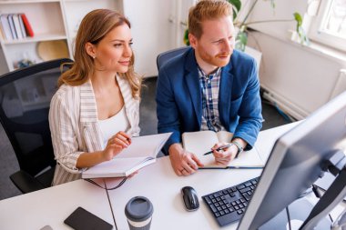 İş arkadaşları sabah brifingi verirken not alıyor, yeni proje üzerinde birlikte çalışıyorlar.