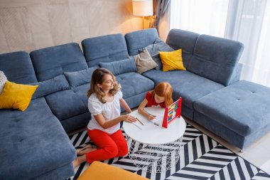 Annenin kızına okul projesinde ve ödevinde yardım etmesi, matematik çalışması, özet çalışması ve çıkarmayı evde birlikte yapması.