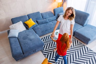 Anne ve kızı evde birlikte vakit geçiriyorlar, müzik dinliyorlar, şarkı söylüyorlar ve dans ediyorlar.