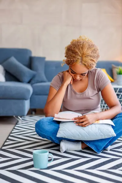 Vacker Ung Afrikansk Kvinna Sitter Vardagsrumsgolvet Läser Tidning Och Dricker — Stockfoto