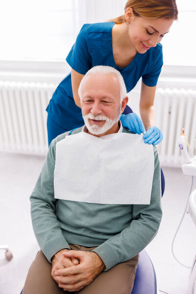 Старший врач в кабинете дантиста сидит в стоматологическом кресле, готовый к осмотру