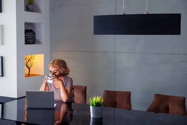 Mulher Bebendo Café Usando Computador Portátil Enquanto Trabalhava Remotamente Casa — Fotografia de Stock