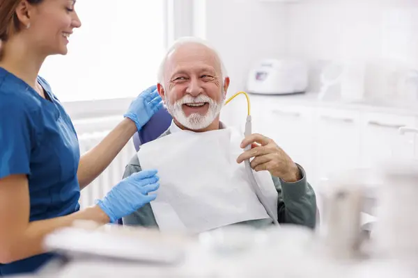 Senior Man Sitting Dentist Chair Holding Saliva Ejector While Doctor — Stock Photo, Image