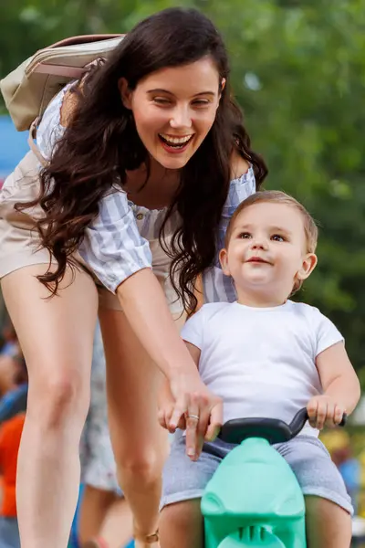 그녀의 귀여운 아들과 야외에서 시간을 즐기는 즐거운 어머니 그에게 자전거를 스톡 사진