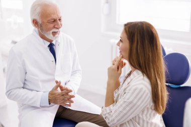 Kadın doktor muayenehanesinde, hasta doktor muayenesinde.