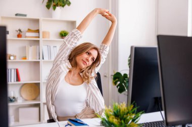 İş yerinde yorucu bir günün ardından ofis masasında uzanan bir kadın.