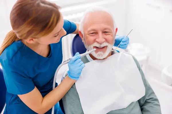 Dentystka Naprawiająca Ząb Pacjenta Klinice Stomatologicznej Pomocą Wiertarki Dentystycznej Lusterka — Zdjęcie stockowe