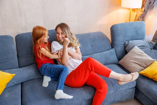 美丽的母亲和小女儿在家里共度闲暇时光 拥抱和欢笑 — 图库照片