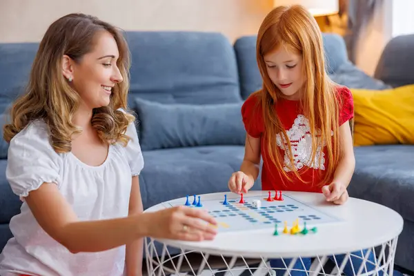 美丽的母亲和女儿一边玩纸牌游戏 一边在家里消磨时光 玩得很开心 — 图库照片